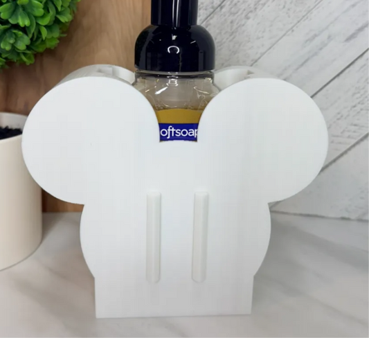 White mouse ears shaped interchangeable soap bottle base with two front attachment rails. Soap bottle shown for display and not included; covers sold separately.