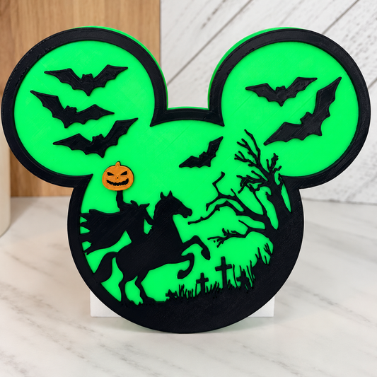 Bright green Mouse Ears cover with black headless horseman, bats, tree and graveyard details and an orange pumpkin. Soap bottle removed with AI; white base shown is not included.