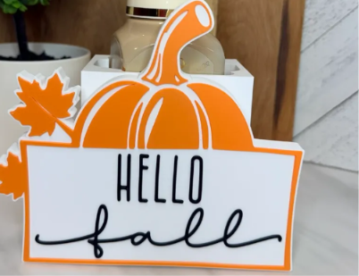 Orange, white and black autumn cover with pumpkin and leaf details and the words Hello Fall. Base and soap bottle shown are not included.