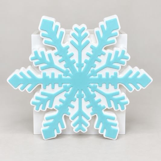 White and light turquoise snowflake cover displayed on an empty white interchangeable base. Base sold separately. Enhanced product photo.